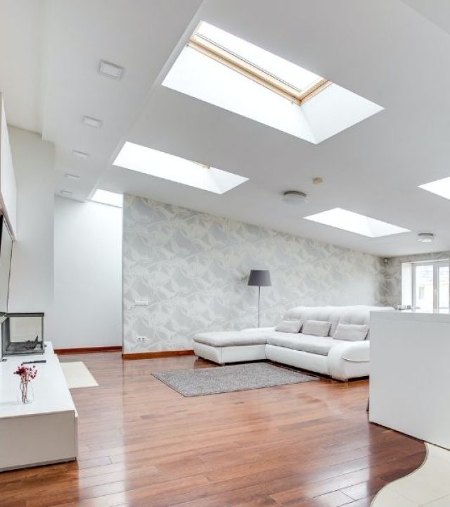 A living room with skylights and a white floor