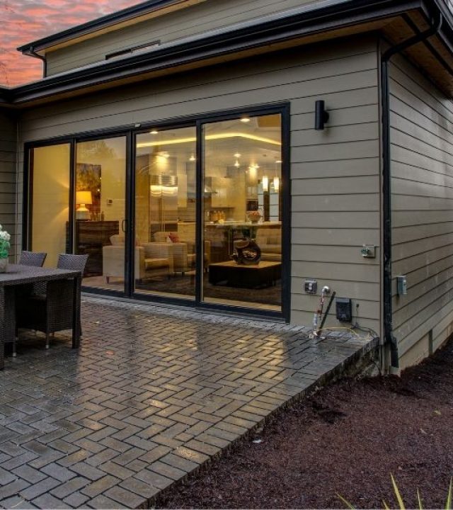 Modern house exterior with a deck at sunset.