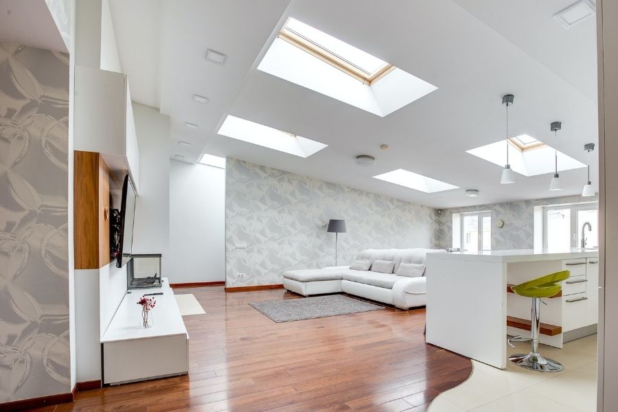 A living room with skylights and a white floor