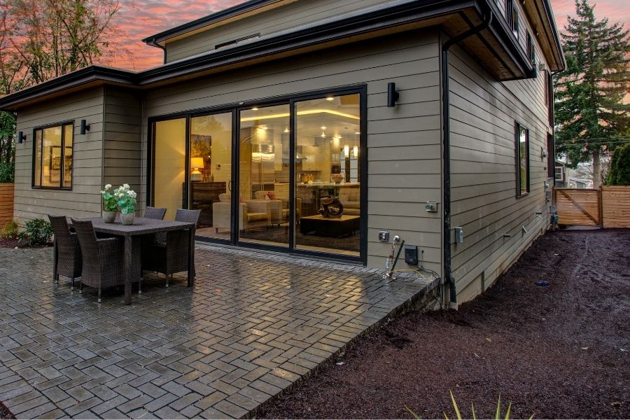 Modern house exterior with a deck at sunset.